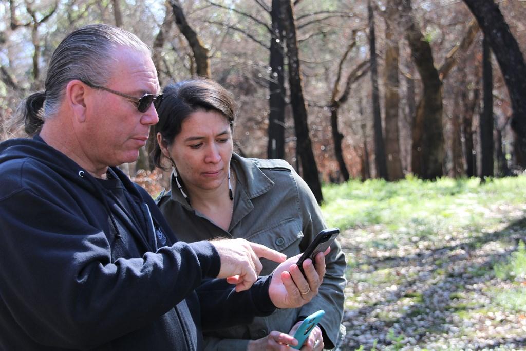 Clint McKay shows Allison Herrera some shots of the burn zone immediately after the fire sm